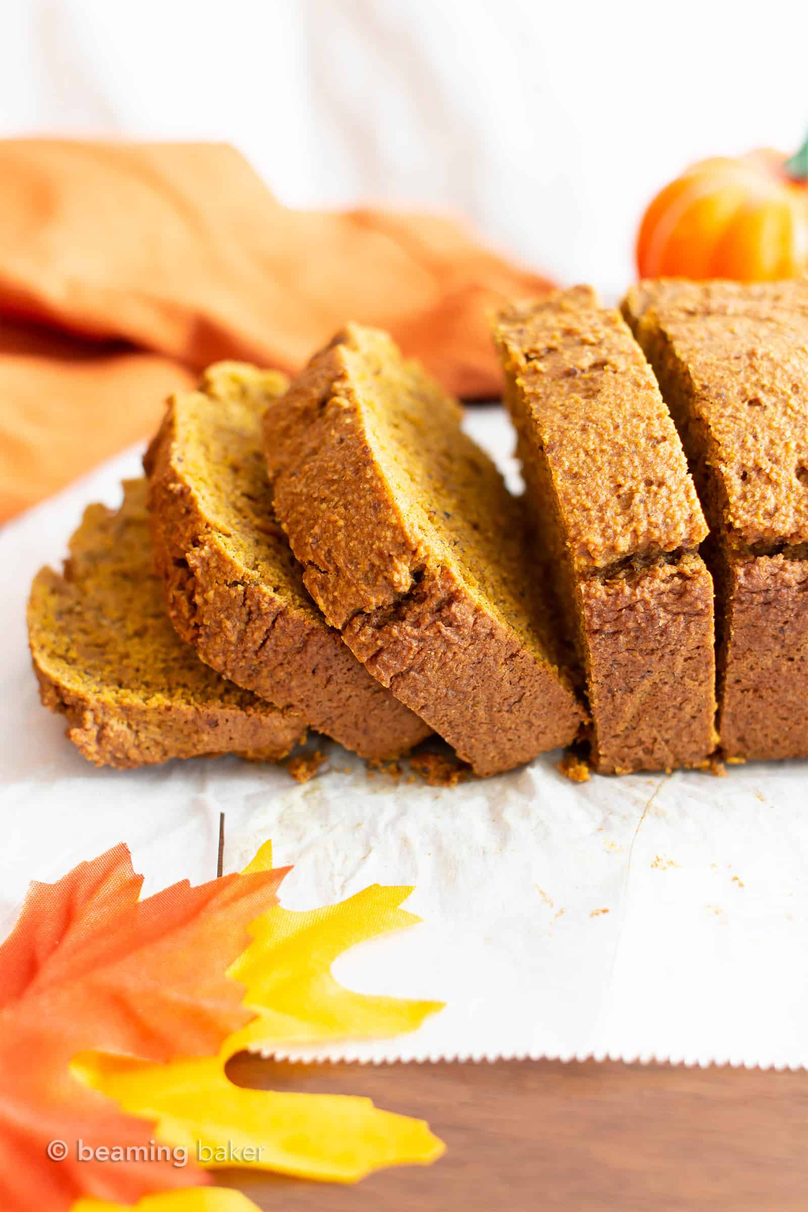 oat flour pumpkin bread slices in side view with pumpkins