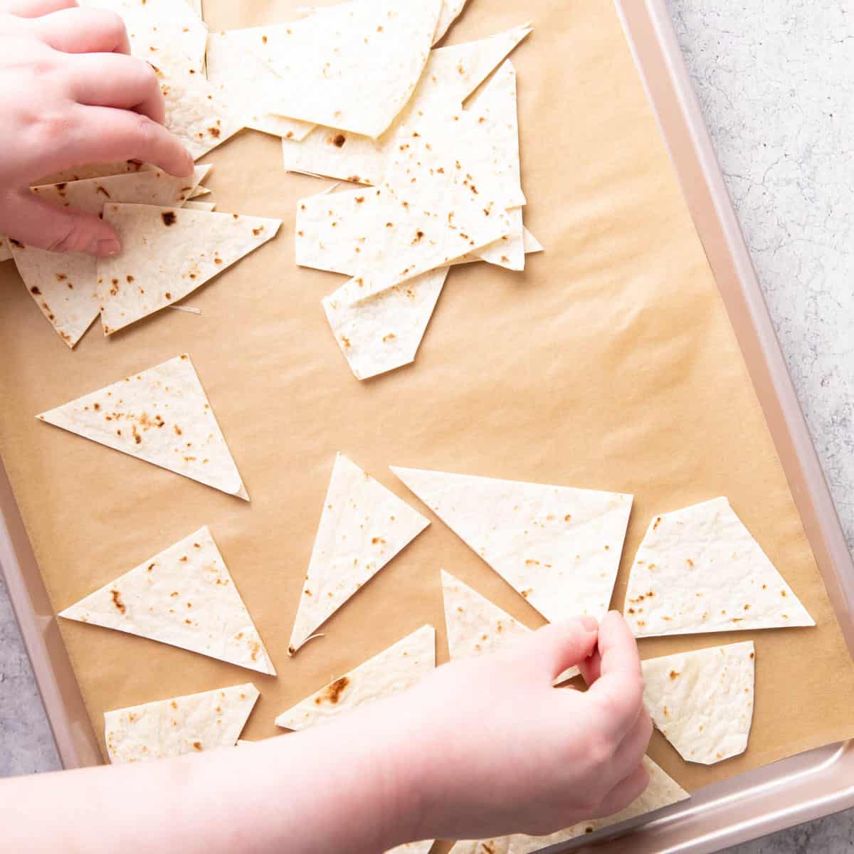 Photo showing How to Make Baked Tortilla Chips – laying tortilla chips on baking sheet