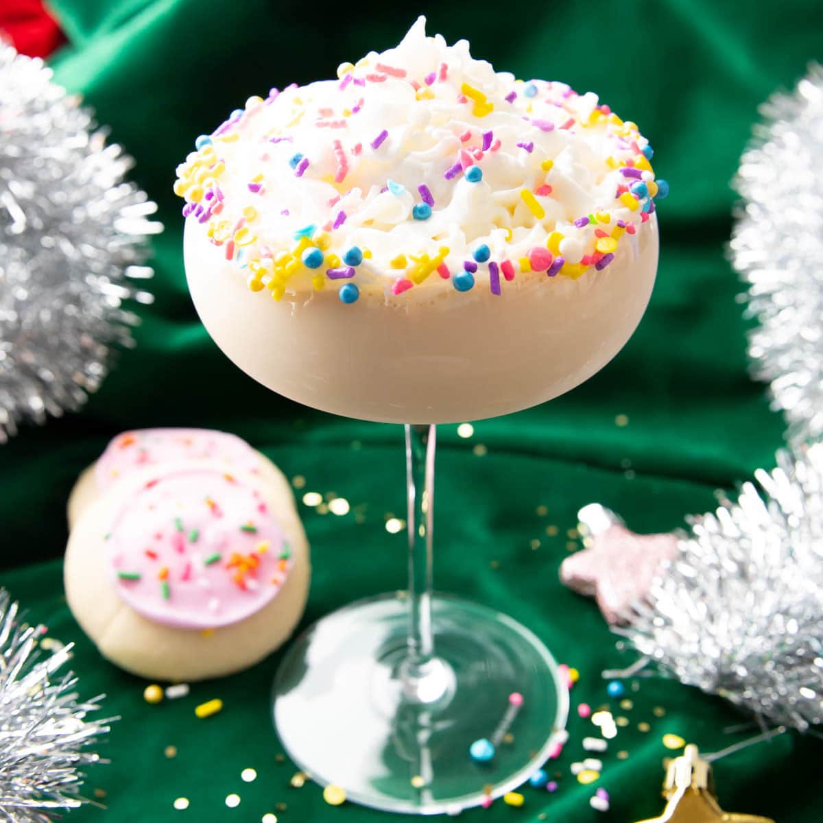 Sugar Cookie Martini served in a glass topped with whipped cream and sprinkles